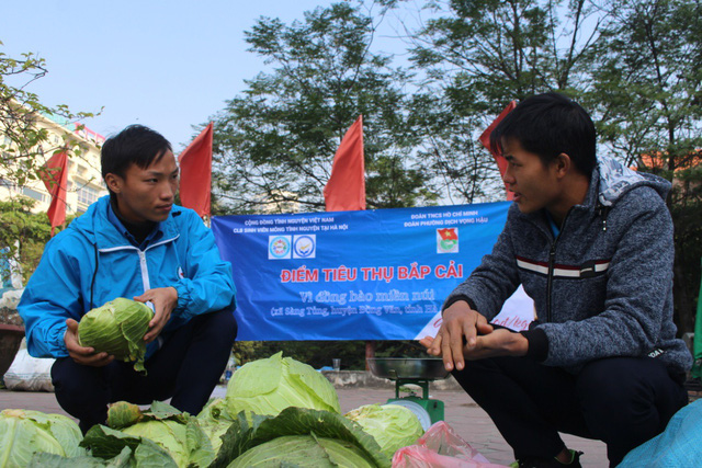  Sùng A Cá tranh thủ trao đổi công việc với Chùa trong lúc bán bắp. Ảnh: Tô Băng 